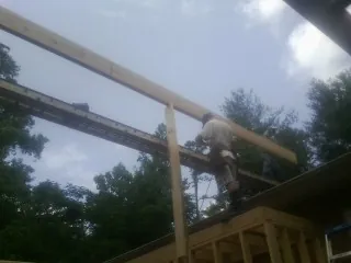 Carpenter setting a ridge beam over a new addition frame — Ice Dam Removal by Roofing Brothers in West Concord