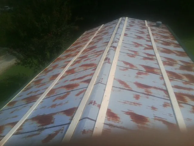 Rusted metal roof panels with new wood purlins before replacement — Storm Damage Roof Repair in West Concord by Roofing Brothers