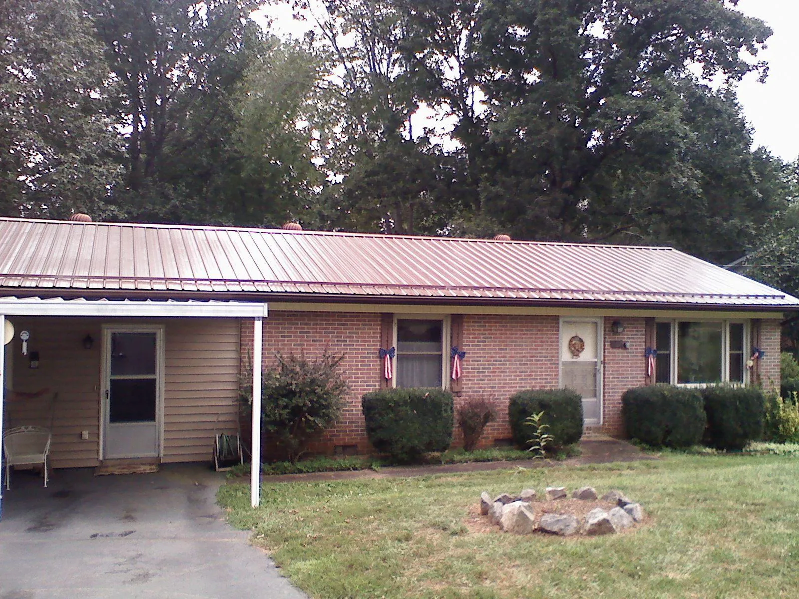 Bronze metal roof and carport on a brick ranch home — Roof Repair work by our crew in West Concord